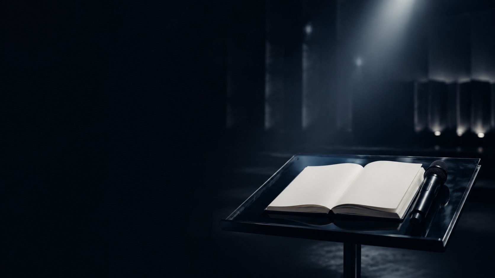 Open book and microphone on a dark stage under soft lighting